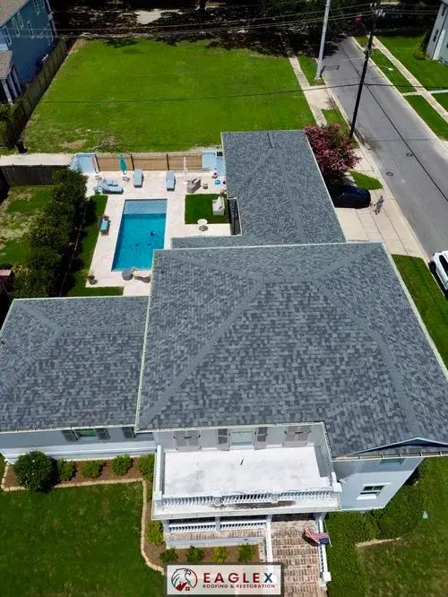 Drone aerial of a large completed shingle roof beside a backyard pool, watermarked with the EagleX logo